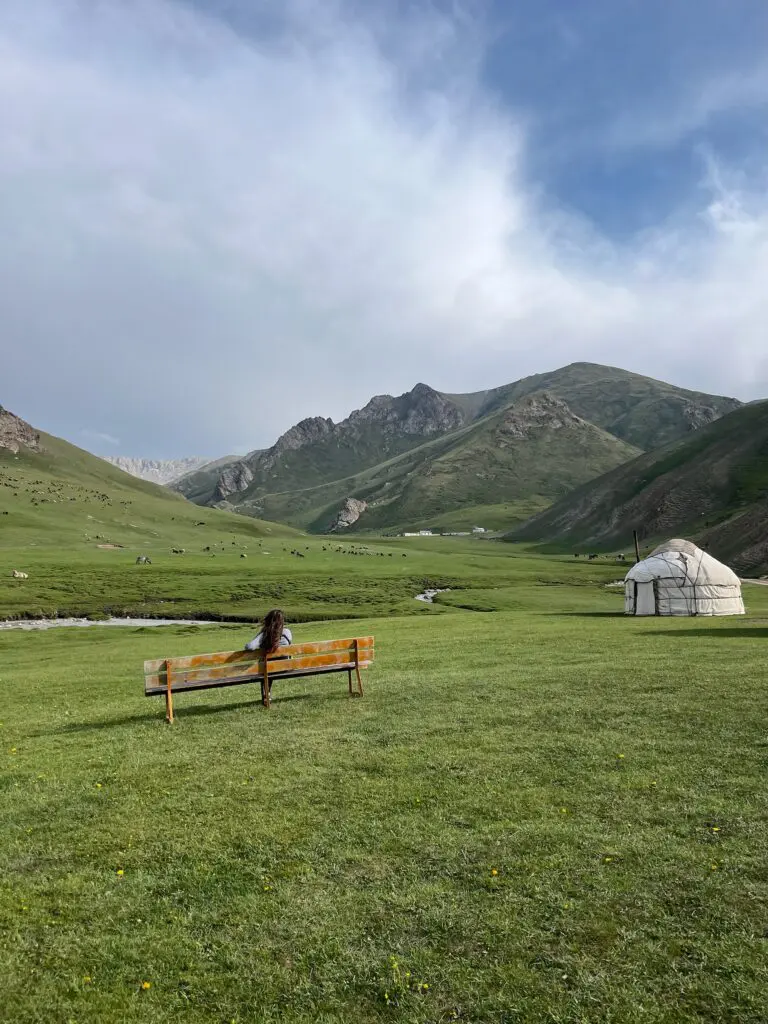 relaxing on a bench in a beautiful landscape with a yurt