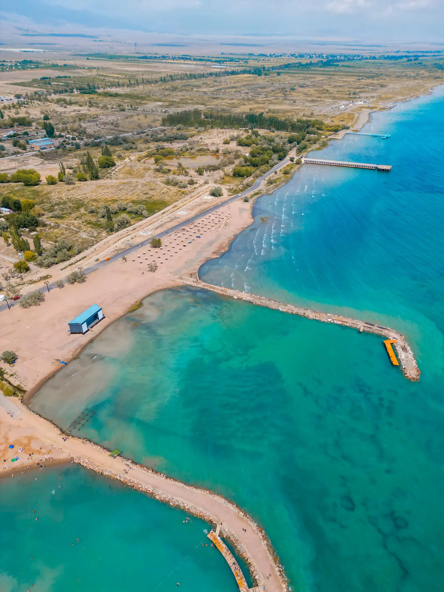 drone-opname van een strand en een pier aan het Issyk-Kulmeer in Kirgizië