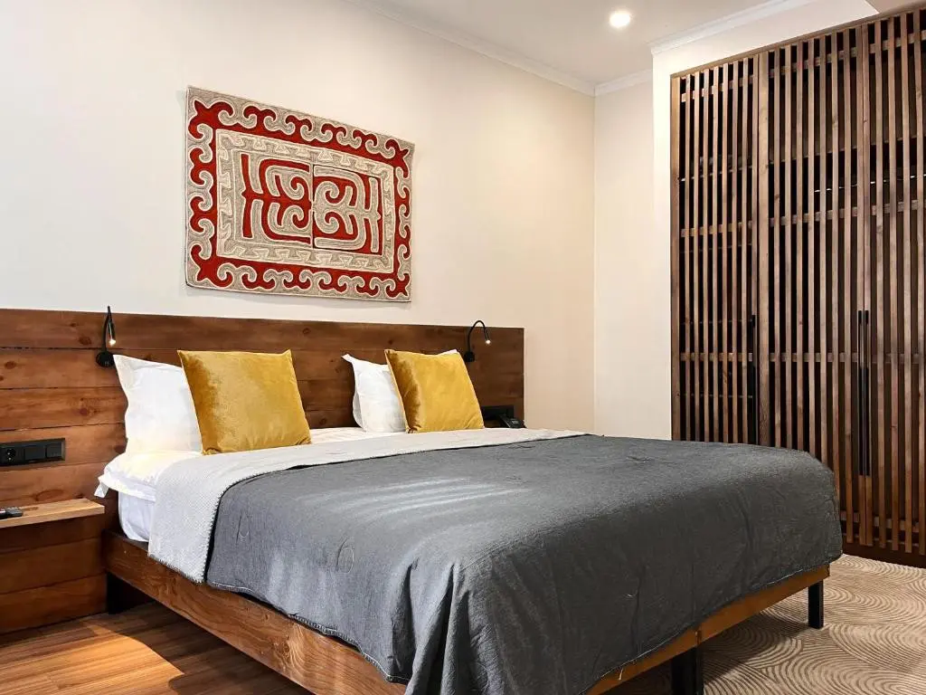 hotel bedroom with wooden bed and decorative tapestry