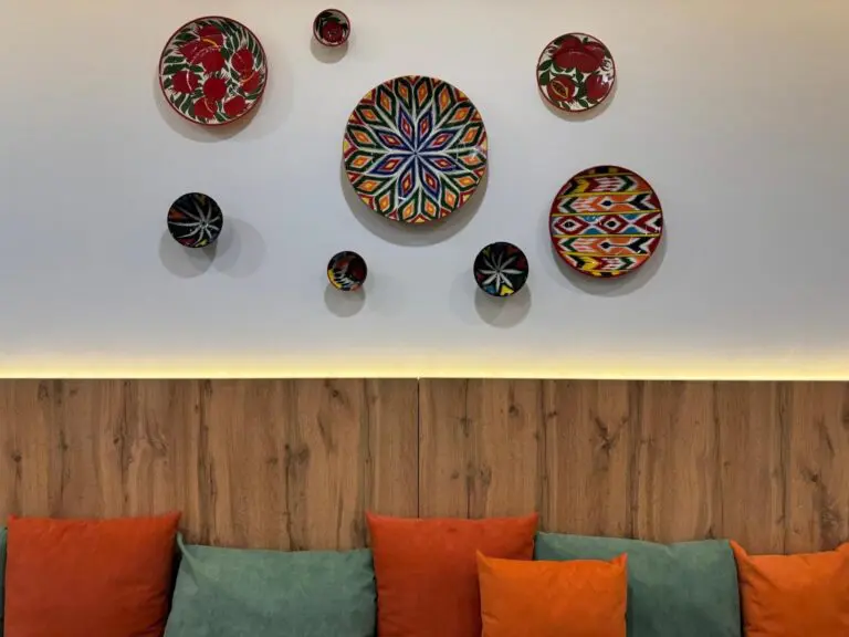 colorful decorative plates on wall above sofa with cushions