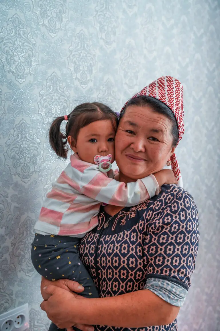 Kyrgyz woman holding a child with a pacifier
