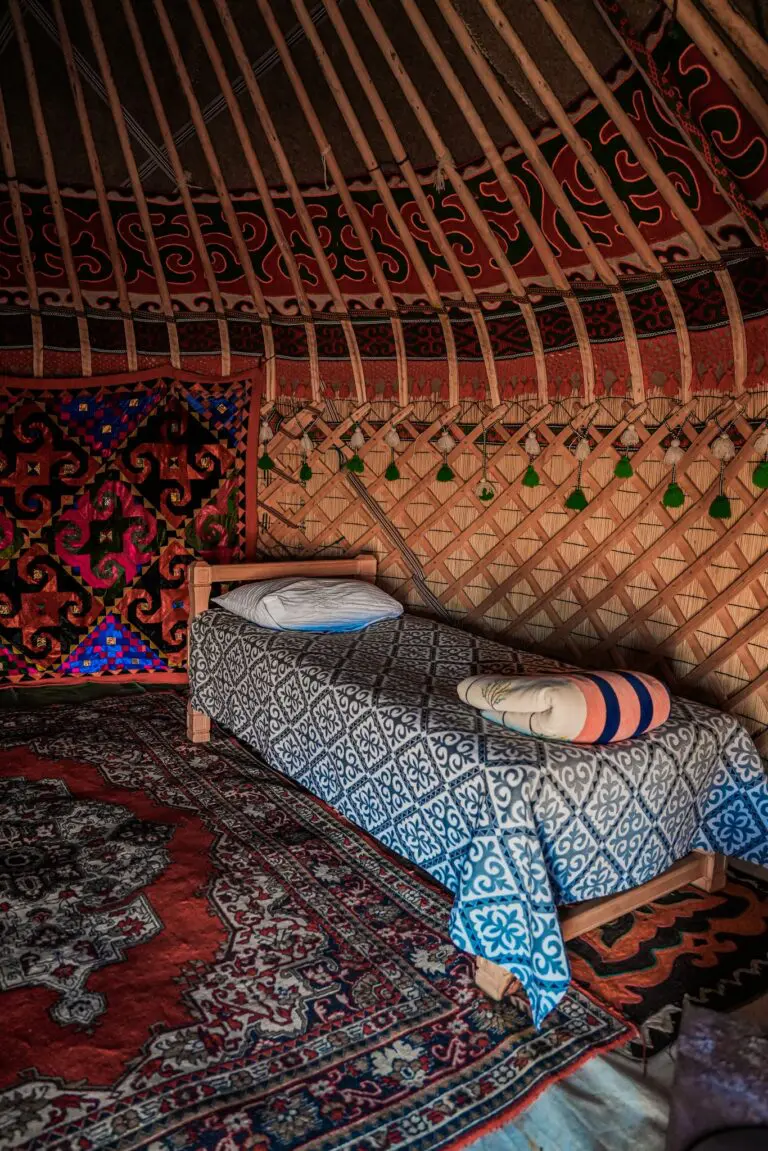 Traditional yurt interior with patterned textiles and a single bed