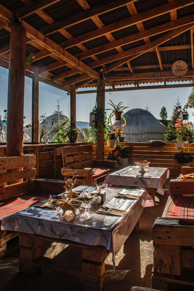 outdoor dining area with wooden furniture and yurt in Kyrgyzstan
