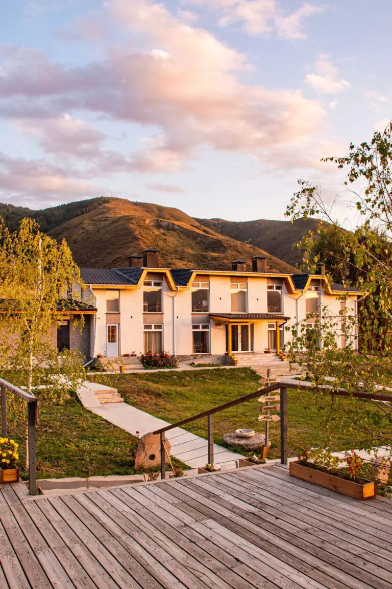 large white building with mountains and sunset clouds in Kyrgyzstan