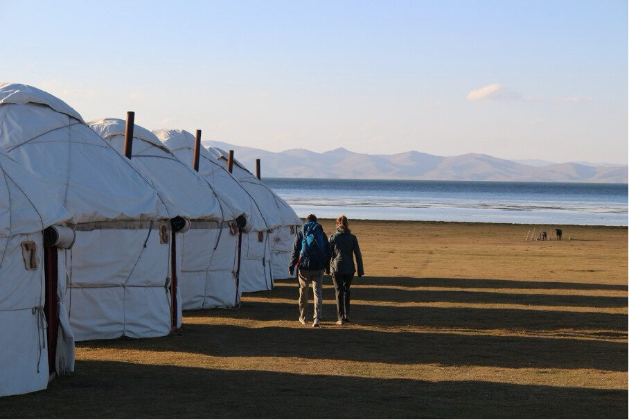 yurtkamp langs het meer met twee mensen die wandelen