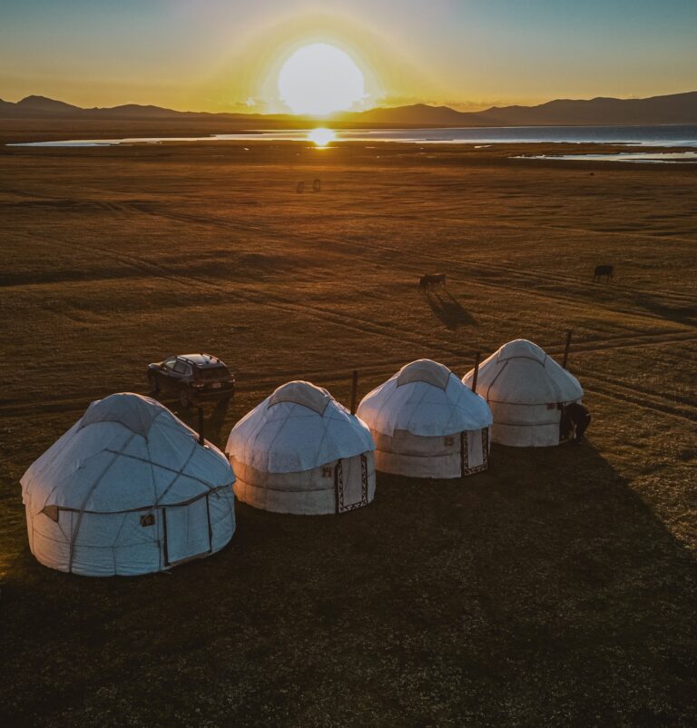 yurt camp at sunset in Kyrgyzstan with lake and mountains
